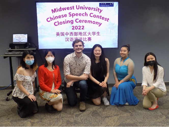 a group of students sitting in front of a banner about the Chinese Language speech contest