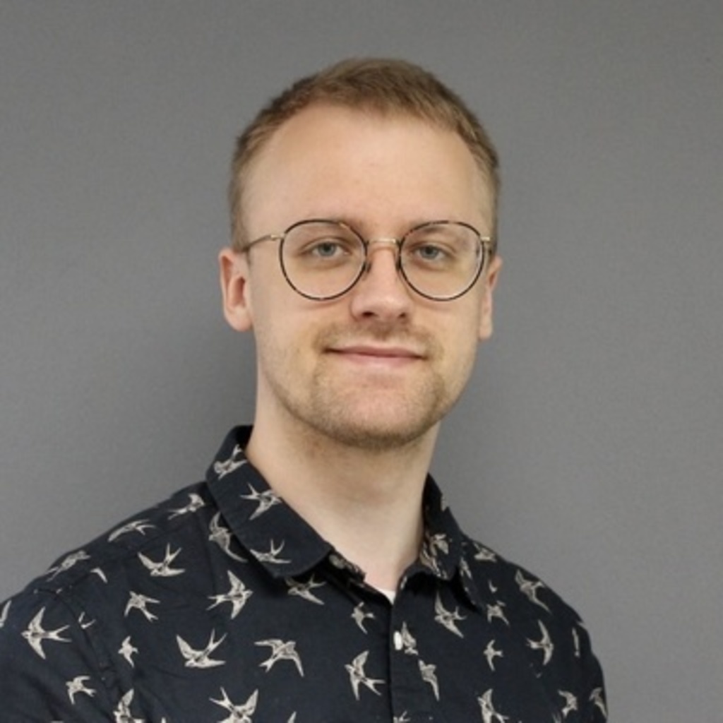 young blond man in dark shirt, smiling