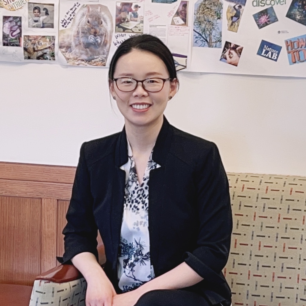 female presenting individual with glasses and a black sport coat